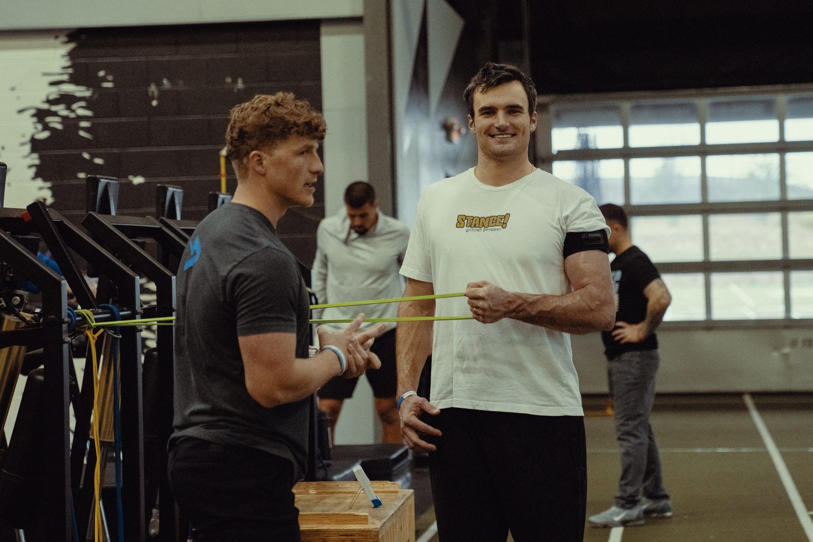 An APEC coach running an athlete through band arm care