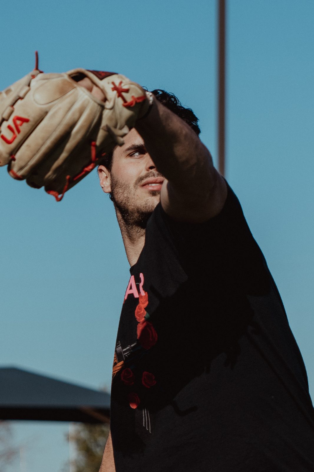 An APEC pitcher setting his glove against the sky