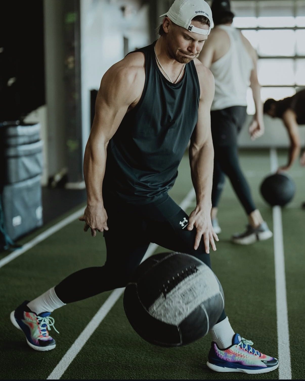 Bobby Witt Jr. driving a medicine ball in a split stance at APEC